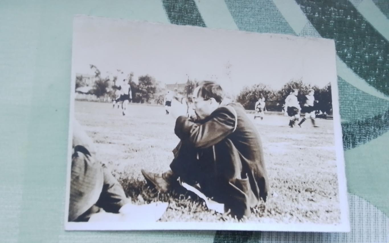 Фото Фотограф или болельщик сидит на неизвестном футболе около поля Конец 1950 г