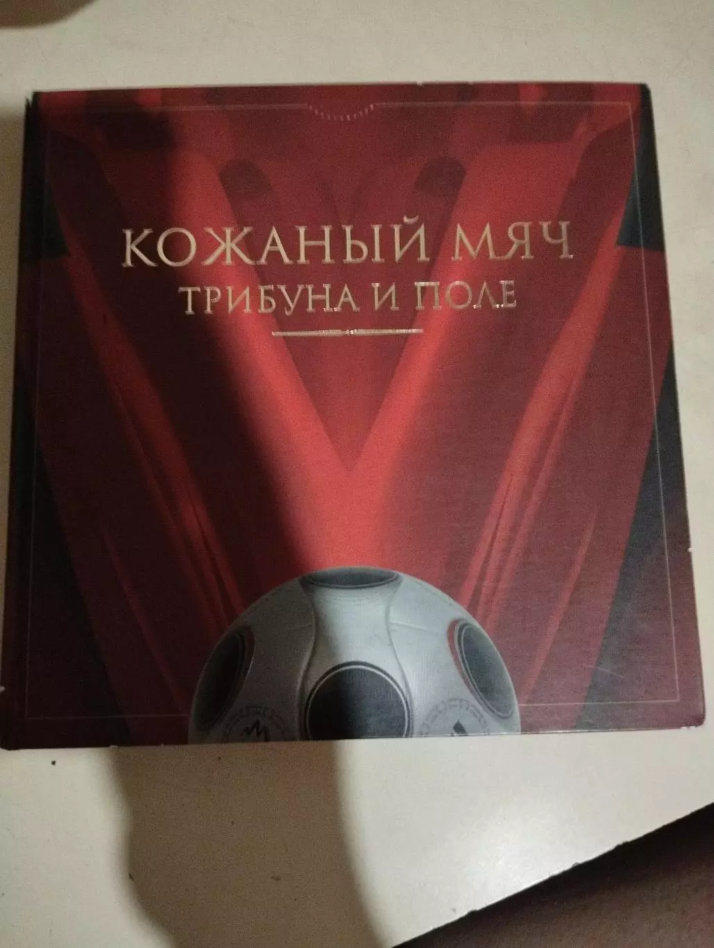 Кожаный мяч, трибуна и поле.