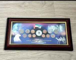 Сувенирное панно: монеты ОАЭ в рамке под стеклом.